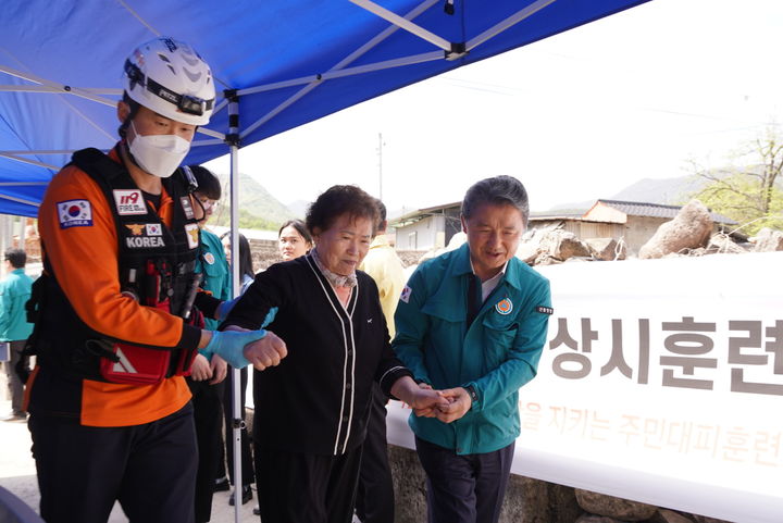 [문경=뉴시스] 남성현(오른쪽 첫째) 산림청장이 22일 경북 문경시 산북면 창구리 마을에서 진행된 '산사태 재난 대비 훈련'에서 재난대응 소방관과 함께 주민을 안전한 대피경로로 안내하고 있다. (사진=산림청 제공) 2024.04.22. photo@newsis.com  *재판매 및 DB 금지