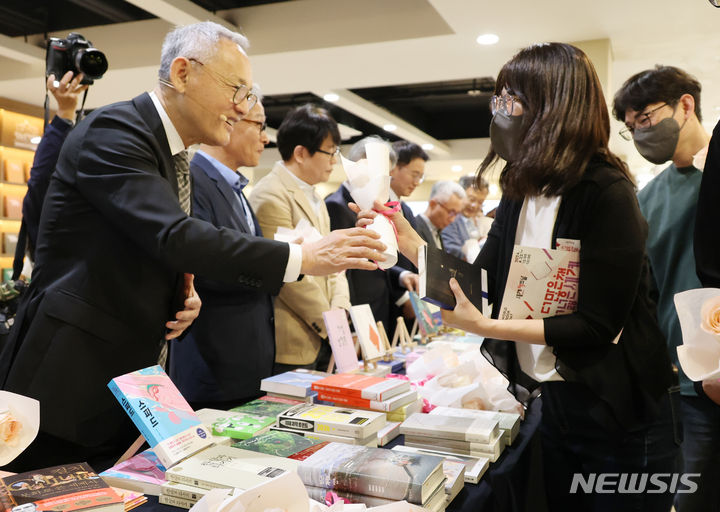 [서울=뉴시스] 김명원 기자 = 유인촌 문화체육관광부 장관이 23일 오전 서울 종로구 세종문화회관 세종라운지에서 열린 세계 책의 날 행사에 참석해 시민들에게 책과 장미꽃을 선물하고 있다. 2024.04.23. kmx1105@newsis.com