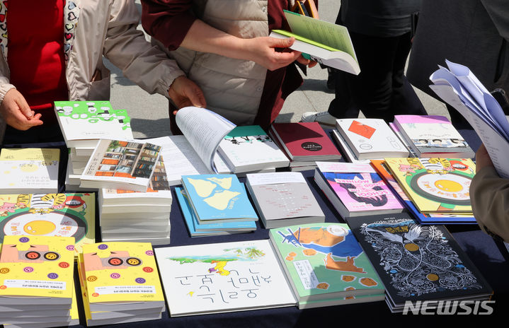 [서울=뉴시스] 최진석 기자 = 유네스코가 정한 세계책의 날인 23일 서울 종로구 광화문 해치마당에서 열린 '책드림 이벤트'에 참가한 시민들이 책을 고르고 있다. 2024.04.23. myjs@newsis.com