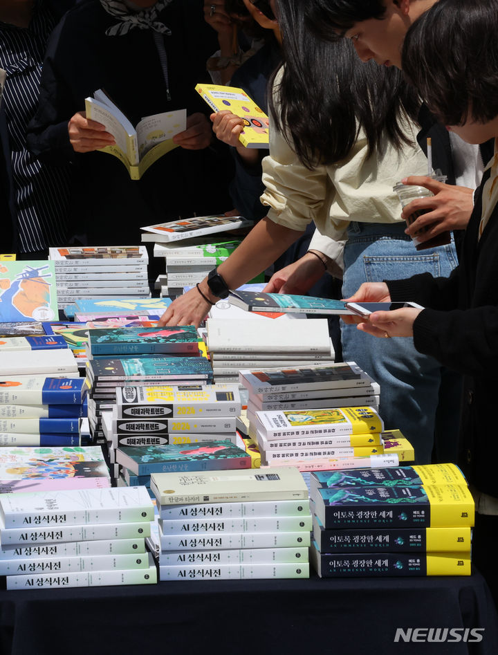 [서울=뉴시스] 최진석 기자 = 유네스코가 정한 세계책의 날인 23일 서울 종로구 광화문 해치마당에서 열린 '책드림 이벤트'에 참가한 시민들이 책을 고르고 있다. 2024.04.23. myjs@newsis.com