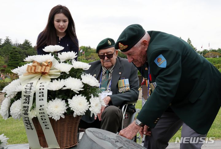 [부산=뉴시스] 하경민 기자 = 23일 부산 남구 유엔기념공원을 방문한 6·25전쟁 캐나다 참전용사들이 전몰장병 묘역 내 캐나다 추모 동상에 헌화한 뒤 명비를 확인하고 있다. 국가보훈부는 가평전투 73주년을 맞아 영연방 4개국(영국, 캐나다, 호주, 뉴질랜드)의 참전용사 6명과 유가족 등 20여 명을 초청했다. 2024.04.23. yulnetphoto@newsis.com