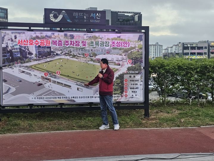 [서산=뉴시스] 김덕진 기자=24일 이완섭 서산시장이 서산중앙호수공원 원형광장에서 가칭 초록광장 조감도를 가리키며 조성 계획을 설명하고 있다. 2024.04.24. spark@newsis.com *재판매 및 DB 금지