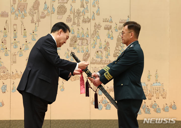 [서울=뉴시스] 전신 기자 = 윤석열 대통령이 24일 서울 용산 대통령실 청사에서 열린 대장 진급·보직 신고 및 삼정검 수치 수여식에서 강호필 합동참모차장의 삼정검에 수치를 달아주고 있다. 2024.04.24. photo1006@newsis.com