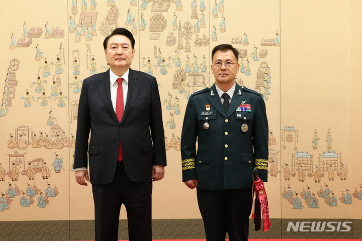 [서울=뉴시스] 전신 기자 = 윤석열 대통령이 24일 서울 용산 대통령실 청사에서 열린 대장 진급·보직 신고 및 삼정검 수치 수여식에서 강호필 합동참모차장의 삼정검에 수치를 달아준 뒤 기념촬영 하고 있다. 2024.04.24. photo1006@newsis.com