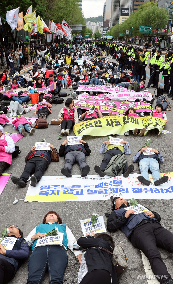 [서울=뉴시스] 김금보 기자 = 전국민주노동조합총연맹 조합원들이 24일 오후 서울 종로구 보신각 앞에서 열린 작업중지권과 산업안전보건법 전면 적용 쟁취를 위한 행진 결의대회에서 노동재해를 추모하는 다이인(die in) 퍼포먼스를 하고 있다. 2024.04.24. kgb@newsis.com