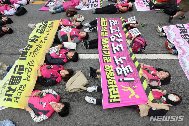 [서울=뉴시스] 김금보 기자 = 전국민주노동조합총연맹 조합원들이 24일 오후 서울 종로구 보신각 앞에서 열린 작업중지권과 산업안전보건법 전면 적용 쟁취를 위한 행진 결의대회에서 노동재해를 추모하는 다이인(die in) 퍼포먼스를 하고 있다. 2024.04.24. kgb@newsis.com