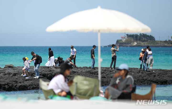 [제주=뉴시스] 우장호 기자 = 맑은 날씨를 보인 25일 오후 제주시 한림읍 협재해수욕장을 찾은 관광객들이 시원한 바닷바람을 쐬며 즐거운 시간을 보내고 있다. 2024.04.25. woo1223@newsis.com