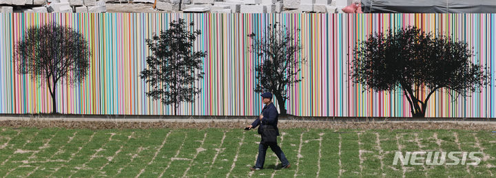[서울=뉴시스] 권창회 기자 = 한 시민이 25일 오후 서울 종로구 덕수궁 선원전터에서 열린 덕수궁 선원전 권역 및 아트펜스 공개행사에서 아트펜스 앞으로 지나가고 있다. 2024.04.25. kch0523@newsis.com