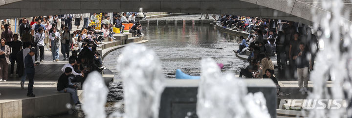 [서울=뉴시스] 정병혁 기자 = 초여름 날씨를 보인 26일 서울 중구 청계천을 찾은 시민들이 의자에 앉아 휴식을 취하고 있다. 2024.04.26. jhope@newsis.com