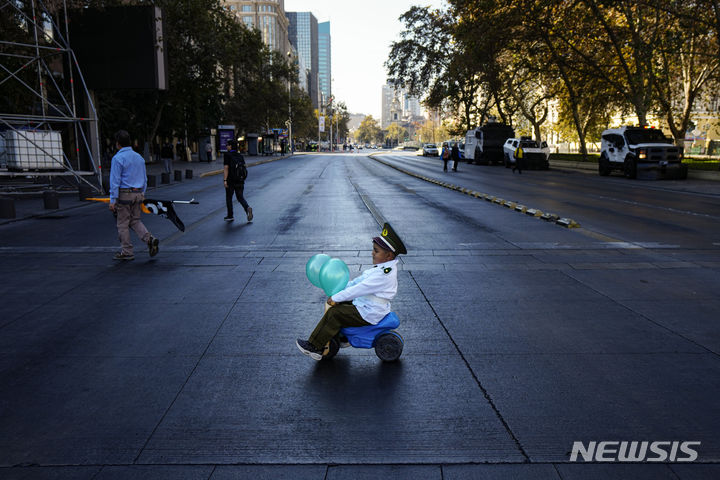 [산티아고(칠레)=AP/뉴시스] 칠레 경찰관들 피살사건에 항의하는 제복차림의 꼬마가 27일 오후 산티아고 시내 도로위에 장난감 자동차를 탄 채 앉아 있다. 2024. 04. 28.&nbsp;&nbsp; 
