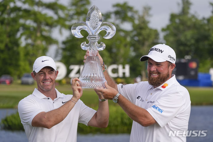 [애번데일=AP/뉴시스] 로리 매킬로이(북아일랜드, 왼쪽)와 셰인 라우리(아일랜드)가 28일(현지시각) 미 루이지애나주 애번데일의 TPC 루이지애나에서 열린 미국프로골프(PGA) 투어 취리히 클래식 정상에 올라 트로피를 들고 포즈를 취하고 있다. 이들은 최종 합계 25언더파 263타로 채드 레이미(미국)-마틴 트레이너(프랑스)와 동타를 이뤄 연장 끝에 우승을 차지했다. 2024.04.29.
