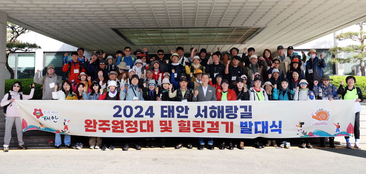 [태안=뉴시스] 지난 27일 태안 군청 현관에서 서해랑길 완주원정대가 발대식 후 현수막을 펼치고 기념 촬영을 하고 있다. (사진=태안군 제공) 2024.04.29. *재판매 및 DB 금지