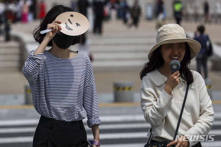 [서울=뉴시스] 정병혁 기자 = 올해 4월은 역대 4월 중 가장 더웠던 것으로 나타났다. 사진은 초여름 날씨를 보인 4월29일 종로구 광화문광장을 찾은 시민이 부채로 머리를 가린 모습. 2024.05.07. jhope@newsis.com