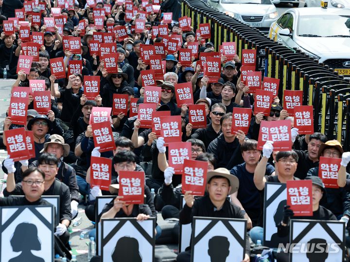 [서울=뉴시스] 고범준 기자 = 지난 4월29일 오후 서울 시청역 인근에서 전국공무원노동조합과 대한민국공무원노동조합총연맹 주최로 열린 공노총, 악성 민원 희생자 추모 공무원노동자대회에서 참석자들이 손 피켓을 들고 구호를 외치고 있다. 2024.04.29. bjko@newsis.com