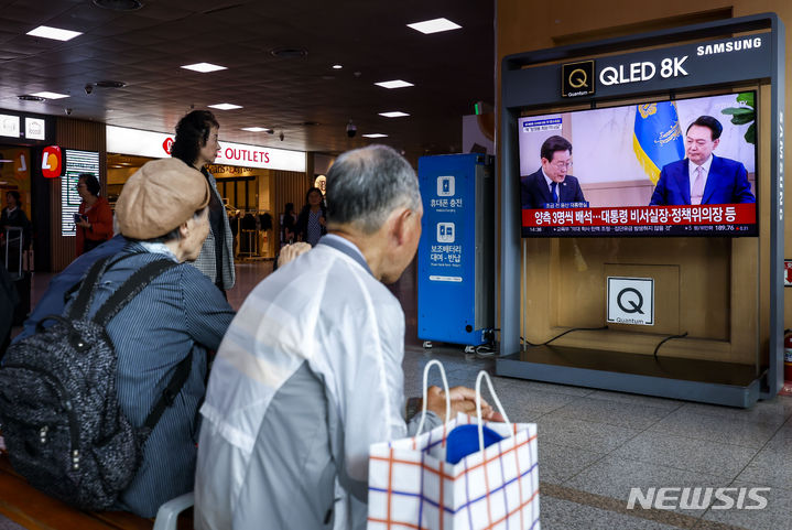 [서울=뉴시스] 정병혁 기자 = 29일 서울 중구 서울역 대합실에서 시민들이 TV를 통해 윤석열 대통령과 이재명 더불어민주당 대표의 영수회담을 바라보고 있다. 2024.04.29. jhope@newsis.com
