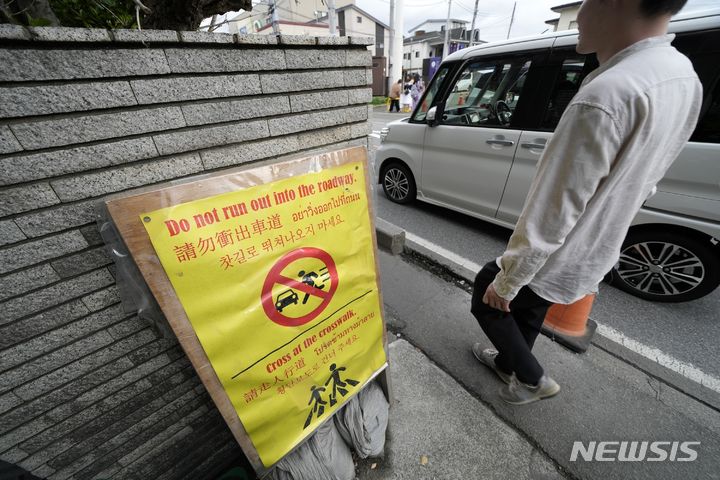 [야마나시현=AP/뉴시스] 4월 30일 일본 야마나시현 후지카와구치코 로손 편의점 맞은편에 관광객을 위한 안내문이 설치돼 있다. 이곳은 로손 편의점 뒤로 펼쳐진 후지산을 찍기 위한 관광객들의 비매너 행동에 몸살을 앓고 있다. 2024.05.29.