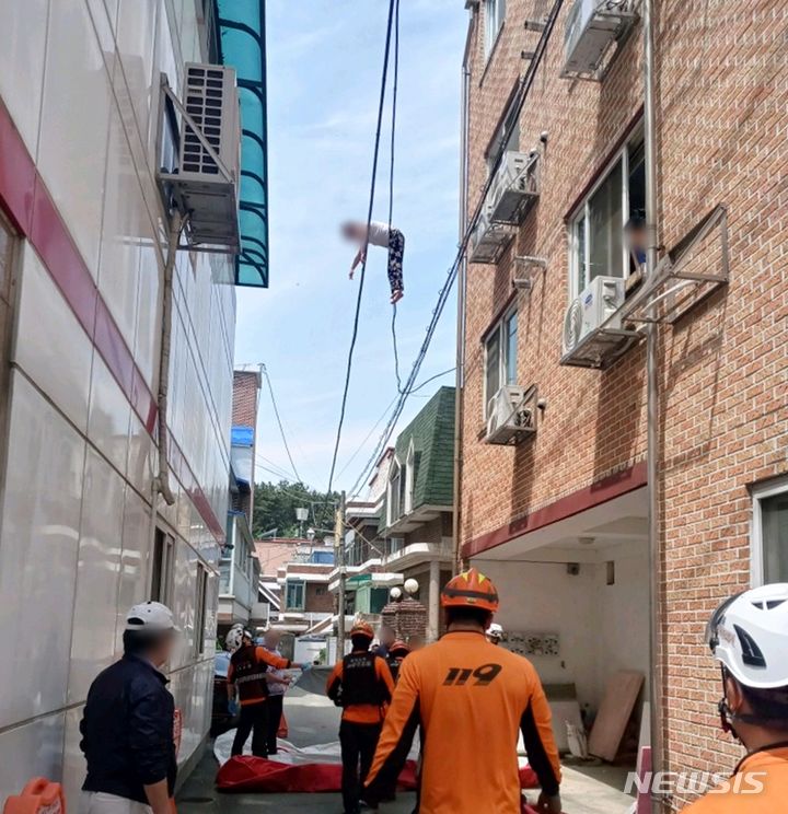 [청주=뉴시스] 조성현 기자 = 지난 1일 오전 11시24분께 충북 청주시 흥덕구 한 주택단지에서 우즈베키스탄 국적의 40대 여성이 6m 높이의 전깃줄에 매달려 있다. (사진 = 독자제공) 2024.05.02. photo@newsis.com *재판매 및 DB 금지