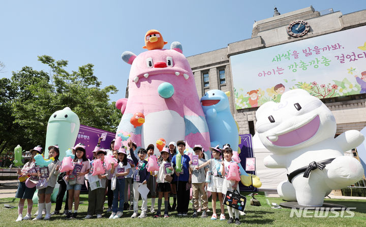 [서울=뉴시스] 김진아 기자 = 2일 서울광장 잔디광장에서 열린&nbsp; '걱정아 사라져라, 얍' 해치의 마법마을 팝업행사에서 서울시 어린이 기자단이 해치와 기념촬영을 하고 있다.&nbsp; 이번 팝업 행사는 새롭게 단장한 시의 상징 캐릭터 해치&소울프렌즈를 알리기 위해 열렸으며, 오는 6일까지 운영한다. 2024.05.02. bluesoda@newsis.com
