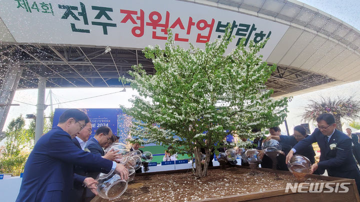 [전주=뉴시스] 김얼 기자 = 우범기(왼쪽, 첫 번째) 전주시장을 비롯한 관계자들이 2일 전북 전주시 전주월드컵경기장 광장에서 열린 '제4회 전주정원산업박람회 개막식'에 참석해 개막 퍼포먼스를 하고 있다. 2024.05.02. pmkeul@newsis.com