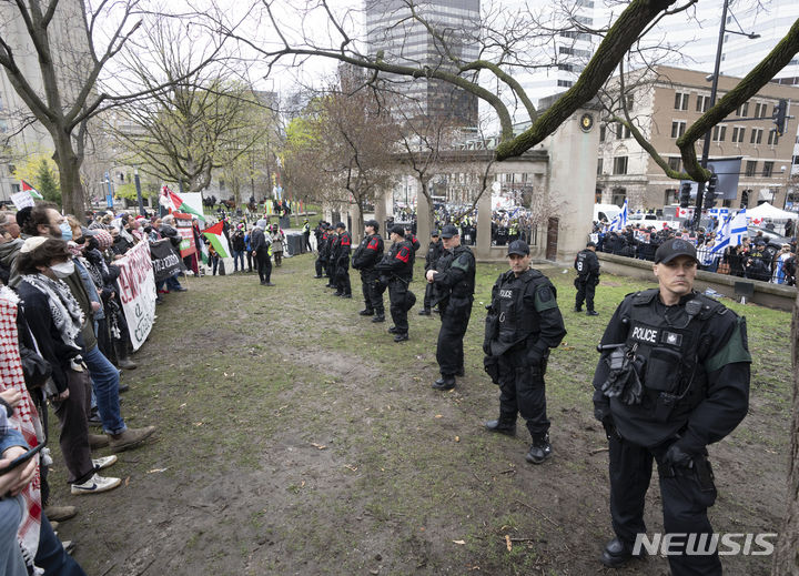 [몬트리올=AP/뉴시스] 2일 캐나다 몬트리올 맥길대에서 경찰이 친 팔레스타인과 친 이스라엘 시위대 중간에 서서 충돌을 막고 있다. 미국 대학내 반 이스라엘 시위는 전 세계로 확대될 조짐을 보이고 있다. 2024.05.03