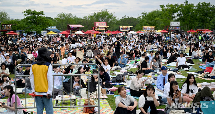 [광주=뉴시스] 김혜인 기자 = 제2회 광산 뮤직 온 페스티벌이 열린 4일 오후 광주 광산구 황룡강친수공원 일대에서 시민들이 돗자리에 앉은 채 공연을 관람하고 있다. 2024.05.04. hyein0342@newsis.com