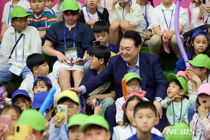 [서울=뉴시스]윤석열 대통령이 5일 청와대 연무관에서 열린 제102회 어린이날 초청행사에서 버블 매직쇼 관람을 위해 자리에 착석 후 어린이들과 인사하고 있다. (사진=대통령실 제공) 2024.05.05. photo@newsis.com