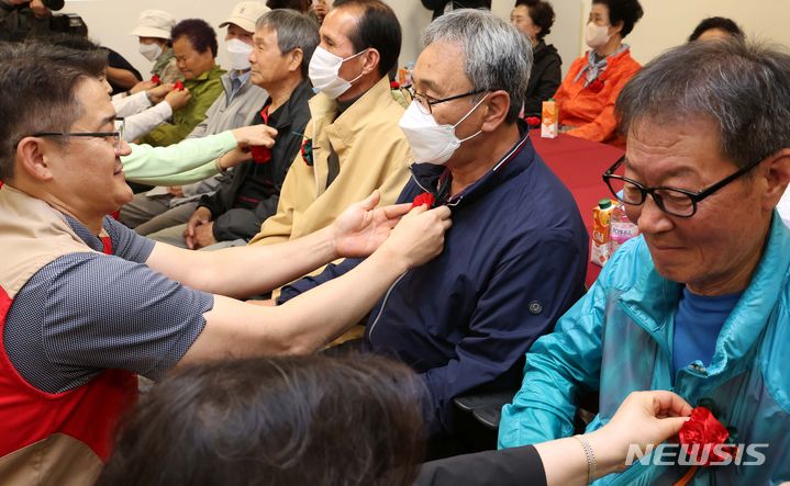 [부산=뉴시스] 하경민 기자 = 어버이날을 하루 앞둔 7일 부산 기장군 롯데프리미엄아울렛 동부산점에서 직원 등으로 구성된 봉사단원들이 초청된 어르신들에게 카네이션을 달아주고 있다. 롯데몰 동부산점과 롯데월푸드, 롯데시네마 등은 어버이날을 맞아 지역 어르신 15명을 초청해 카네이션 선물을 비롯해 점심식사 대접, 기념품 제공, 영화관람 등을 지원했다. 2024.05.07. yulnetphoto@newsis.com