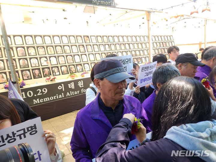 [서울=뉴시스] 이수정 기자=8일 서울광장에서 열린 어버이날 행사에 청년들이 참석해 이태원 참사 유가족에 카네이션을 달아주고 있다. crystal@newsis.com