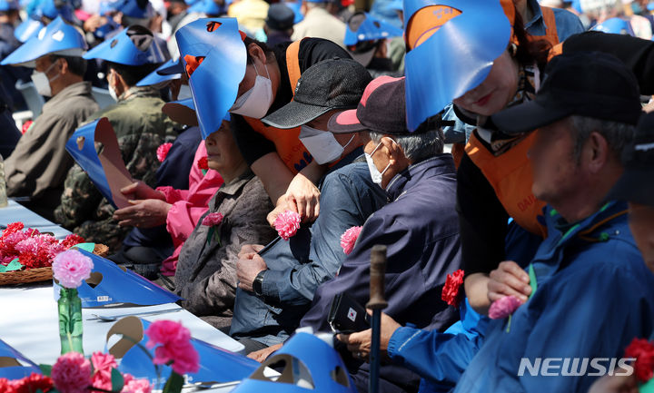 [서울=뉴시스] 추상철 기자 = 어버이날인 8일 오전 서울 동대문구 밥퍼나눔운동본부 앞마당에서 열린 다일공동체의 '어버이날 효도잔치'에서 자원봉사자들이 어르신에게 카네이션을 달아 주고 있다. 2024.05.08. scchoo@newsis.com