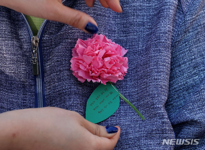 [서울=뉴시스] 추상철 기자 = 어버이날인 8일 오전 서울 동대문구 밥퍼나눔운동본부 앞마당에서 열린 다일공동체의 '어버이날 효도잔치'에서 자원봉사자가 어르신에게 카네이션을 달아 주고 있다. 2024.05.08. scchoo@newsis.com