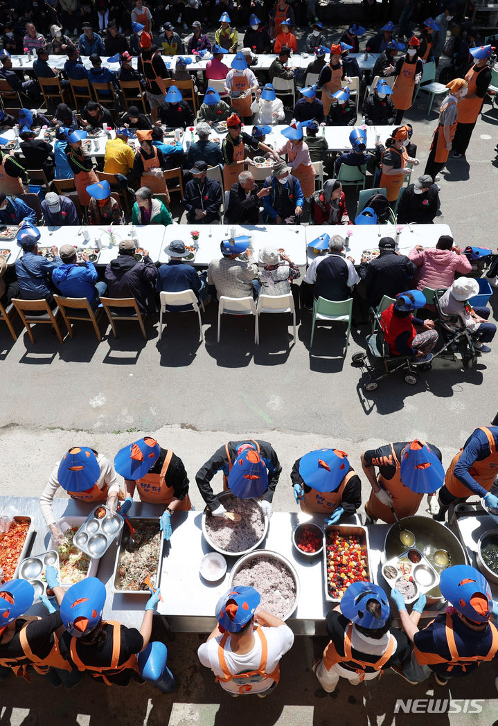 [서울=뉴시스] 추상철 기자 = 어버이날인 8일 오전 서울 동대문구 밥퍼나눔운동본부 앞마당에서 열린 다일공동체의 '어버이날 효도잔치'에서 자원봉사자들이 어르신에게 무료배식을 하고 있다. 2024.05.08. scchoo@newsis.com