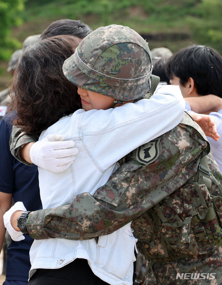 [세종=뉴시스] 강종민 기자 = 8일 세종시 육군 32사단 신병교육대대 연병장에서 열린 수료식에서 한 장병의 부모가 그동안 고생한 아들을 안아주고 있다. 2024.05.07. ppkjm@newsis.com