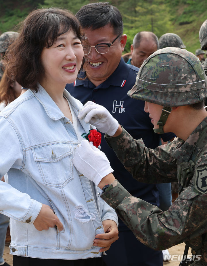 [세종=뉴시스] 강종민 기자 = 어버이날인 8일 세종시 육군 32사단 신병교육대대 연병장에서 열린 수료식에서 한 장병이 부모 가슴에 카네이션을 달아 주고 있다. 2024.05.07. ppkjm@newsis.com