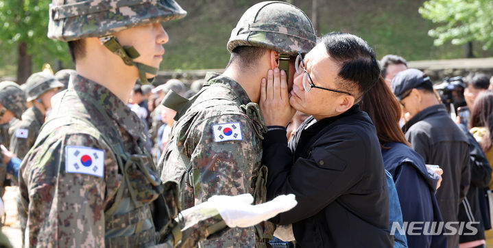 [세종=뉴시스] 강종민 기자 = 8일 세종시 육군 32사단 신병교육대대 연병장에서 열린 수료식에서 한 장병의 부모가 그동안 고생한 아들을 어루만지고 있다. 2024.05.07. ppkjm@newsis.com