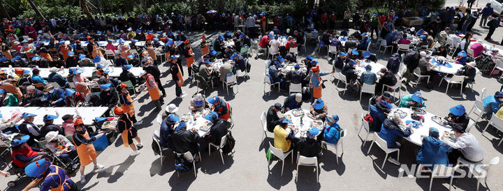 [서울=뉴시스] 추상철 기자 = 어버이날인 8일 오전 서울 동대문구 밥퍼나눔운동본부 앞마당에서 열린 다일공동체의 '어버이날 효도잔치'에서 자원봉사자들이 어르신에게 무료배식을 하고 있다. 2024.05.08. scchoo@newsis.com