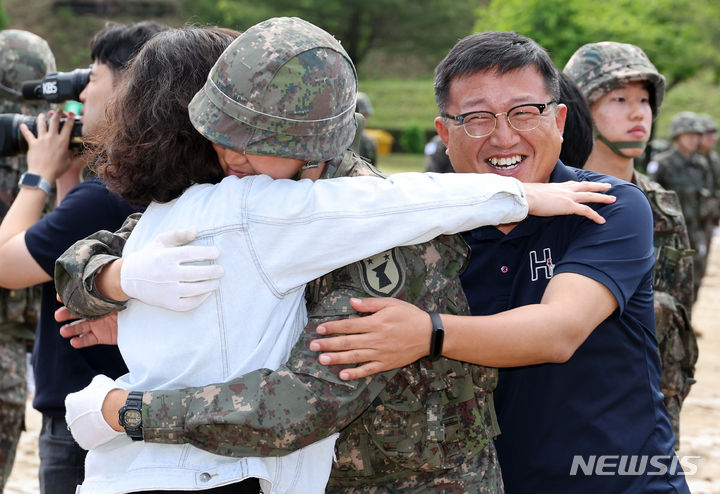 [세종=뉴시스] 강종민 기자 = 어버이날인 8일 세종시 육군 32사단 신병교육대대 연병장에서 열린 수료식에서 한 신병이 부모님을 안아 주고 있다. 2024.05.07. ppkjm@newsis.com