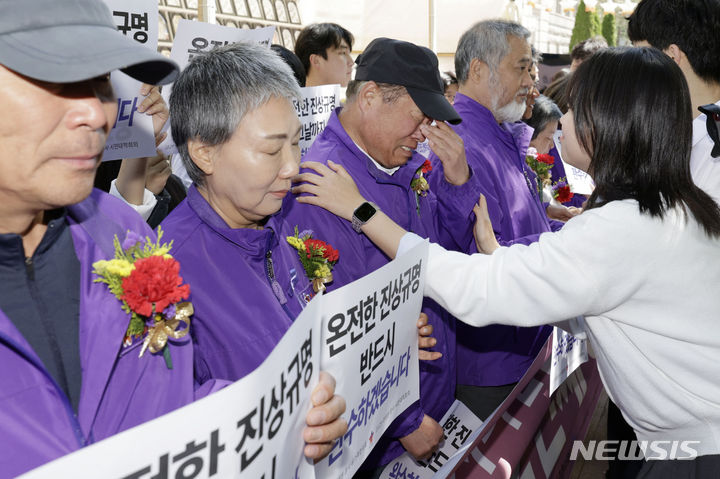 [서울=뉴시스] 최동준 기자 = 이태원 참사 희생자 부모들이 8일 서울 중구 서울광장 분향소 앞에서 열린 '거리에서 맞는 2번째 어버이날' 온전한 진상규명 촉구 기자회견 중 청년들이 카네이션을 달아주자 슬퍼하고 있다. 2024.05.08. photocdj@newsis.com