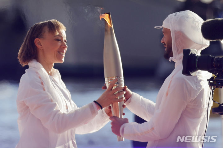 [마르세유=AP/뉴시스] 8일(현지시각) 프랑스 마르세유에서 열린 2024 파리올림픽 성화 환영식에서 프랑스 패럴림픽 선수인 난테닌 케이타가 래퍼 줄에게 성화를 전달하고 있다. 2024.05.09.