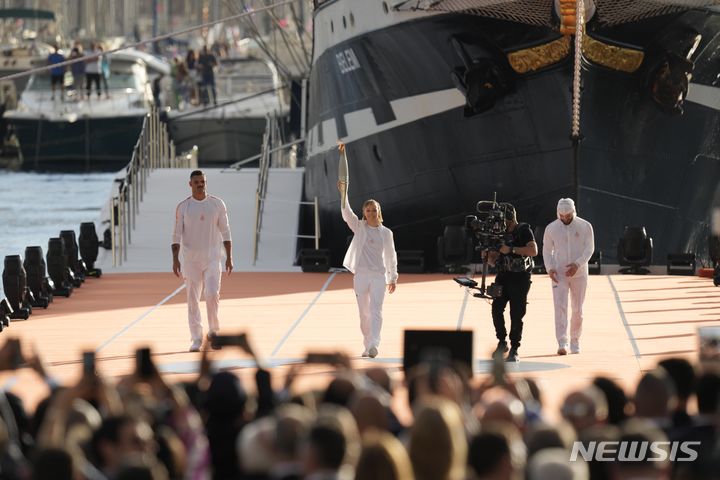 [마르세유=AP/뉴시스] 프랑스 패럴림픽 선수 난테닌 케이타(가운데)가 프랑스 남부 마르세유에서 열린 성화 도착식에서 성화를 들고 있다. 2024.05.09.
