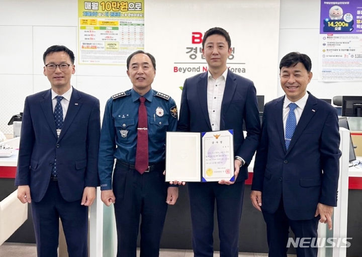 [창원=뉴시스]BNK경남은행 중리지점 직원(오른쪽서 두 번째)이 보이스피싱 예방 공로로 마산동부경찰서 관계자로부터 감사장을 받고 있다.(사진=BNK경남은행 제공0 2024.05.09. photo@newsis.com