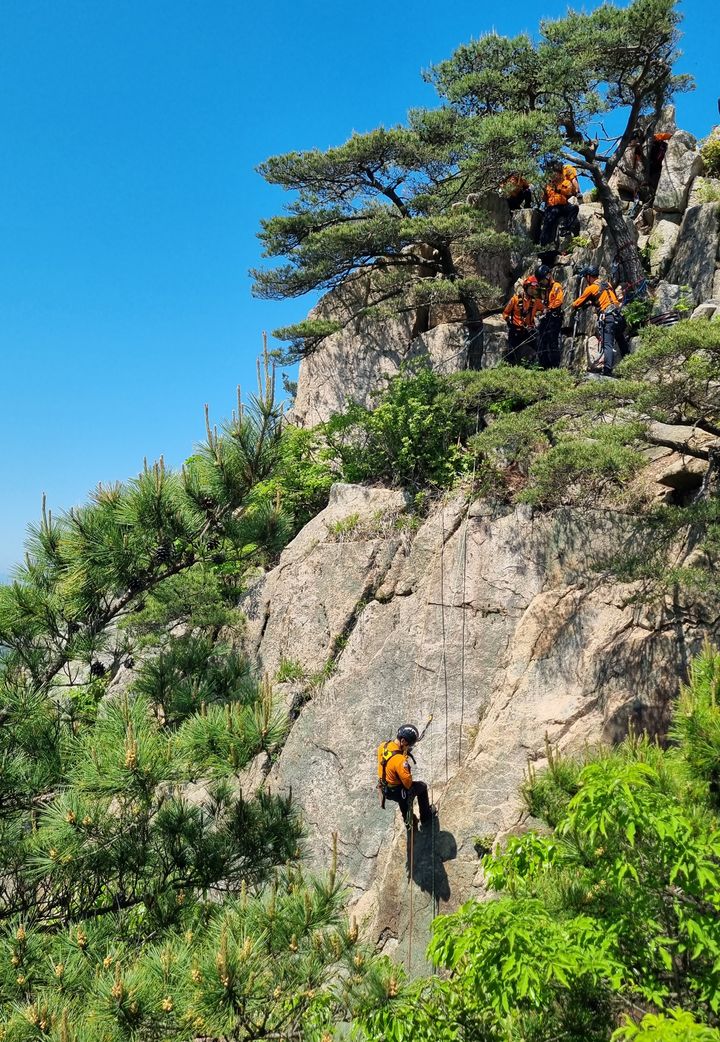 [창녕=뉴시스] 창녕소방서가 관룡산 병풍바위에서 봄철 산악사고 대응 향상 관룡산 구조·구급훈련을 하고 있다. (사진=창녕소방서 제공) 2024.05.09. photo@newsis.com *재판매 및 DB 금지