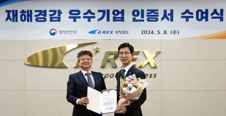 [서울=뉴시스] 지난 8일 인천 서구 공항철도 본사에서 열린 재해경감 우수기업 인증서 수여식에서 김이배(오른쪽) 공항철도수송본부장이 김용균 행안주 안전예방정책실장에게 '재해경감 우수기업 재인증'을 받고 있다.. 2024.05.09. (사진=공항철도 제공) photo@newsis.com *재판매 및 DB 금지