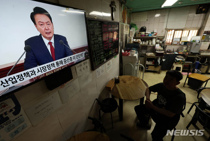 [서울=뉴시스] 김명년 기자 = 9일 오전 서울시내 한 재래시장에서 상인이 윤석열 대통령 취임 2주년 기자회견을 시청하고 있다. 2024.05.09. kmn@newsis.com