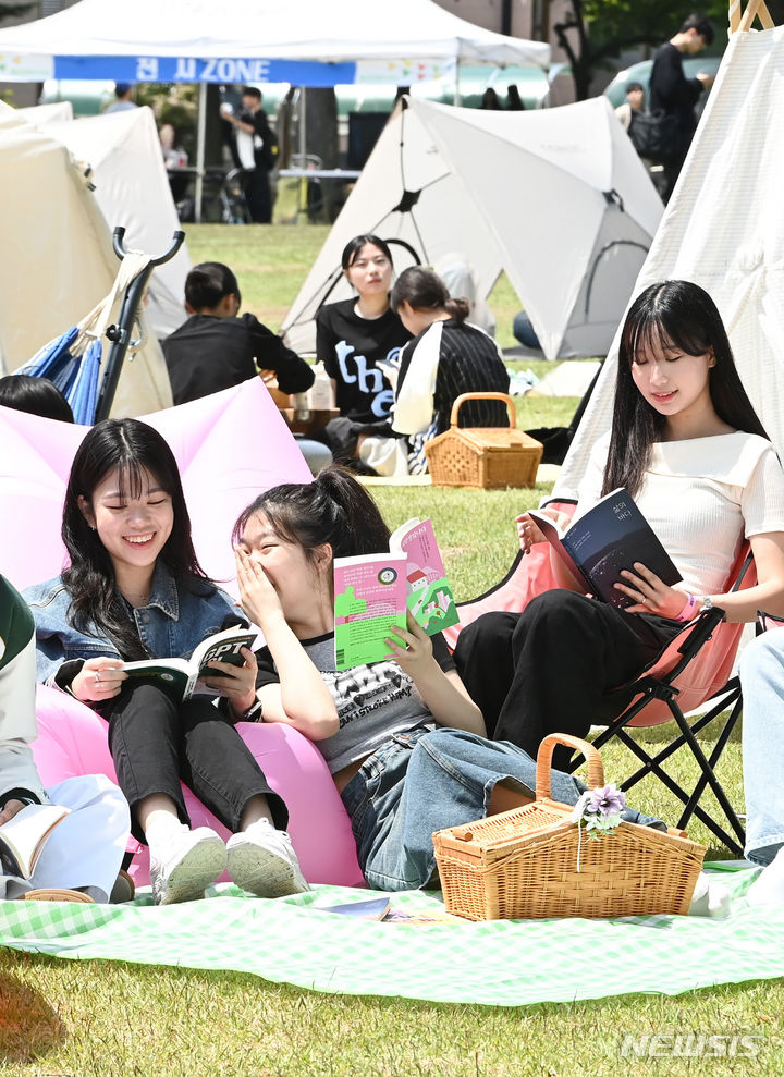 [수원=뉴시스] 김종택기자 = 9일 경기도 수원시 성균관대학교 자연과학캠퍼스 잔디밭에서 '북 피크닉' 행사에 참여한 학생들이 이야기를 나누며 책을 읽고 있다. 2024.05.09. jtk@newsis.com