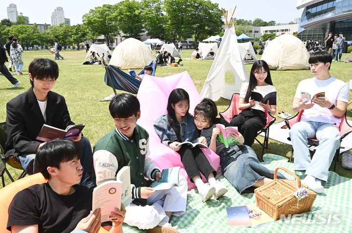 [수원=뉴시스] 김종택기자 = 9일 경기도 수원시 성균관대학교 자연과학캠퍼스 잔디밭에서 '북 피크닉' 행사에 참여한 학생들이 이야기를 나누며 책을 읽고 있다. 2024.05.09. jtk@newsis.com