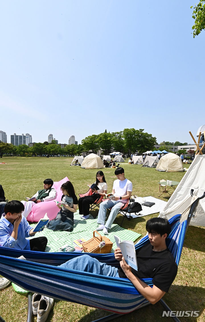 [수원=뉴시스] 김종택기자 = 화창한 날씨를 보인 9일 경기도 수원시 성균관대학교 자연과학캠퍼스 잔디밭에서 '북 피크닉' 행사에 참여한 학생들이 독서를 하고 있다. 2024.05.09. jtk@newsis.com