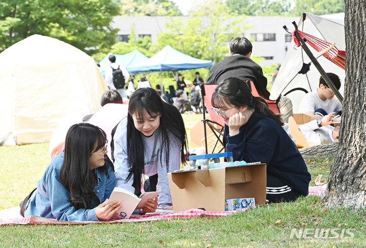 [수원=뉴시스] 김종택기자 = 9일 경기도 수원시 성균관대학교 자연과학캠퍼스 잔디밭에서 '북 피크닉' 행사에 참여한 학생들이 이야기를 나누며 책을 읽고 있다. 2024.05.09. jtk@newsis.com