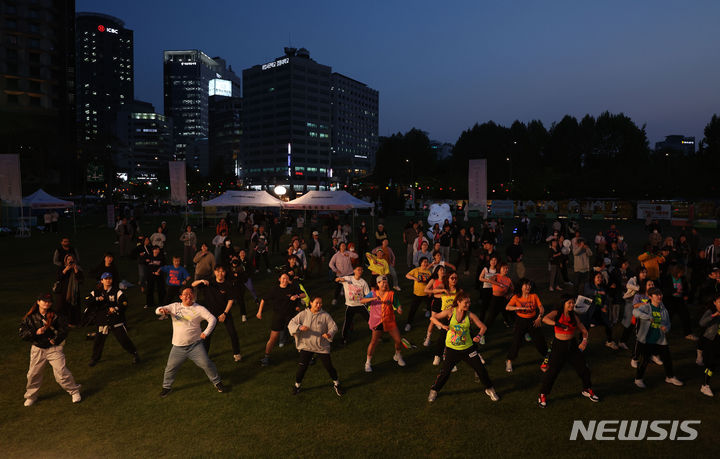 [서울=뉴시스] 김선웅 기자 = 9일 서울시청 광장에서 시민들이 서울시가 운영하는 '운동하는 서울광장' 프로그램에 참여해 줌바댄스를 추고 있다.   도심 속 광장에서 운동을 즐길 수 있는 시민 참여형 생활체육 프로그램 '운동하는 서울광장'은 줌바 댄스, 서킷 트레이닝, 핏 댄스 등 메인 운동과 운동처방소, 운동왕 선발 등으로 구성됐으며 5월 9일부터 혹서기 7~8월을 제외한 10월까지 운영된다. 참가 신청은 공식 홈페이지나 당일 현장 접수를 통해 가능하다. 2024.05.09. mangusta@newsis.com