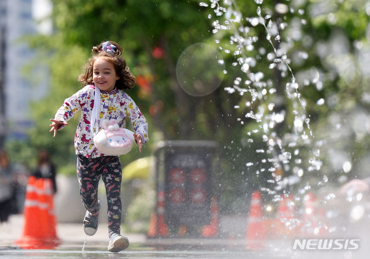 [서울=뉴시스] 홍효식 기자 = 따뜻한 봄 날씨를 보인 10일 서울 종로구 광화문광장을 찾은 한 외국인 어린이가 터널 분수를 뛰어다니며 환하게 웃고 있다. 2024.05.10. yesphoto@newsis.com
