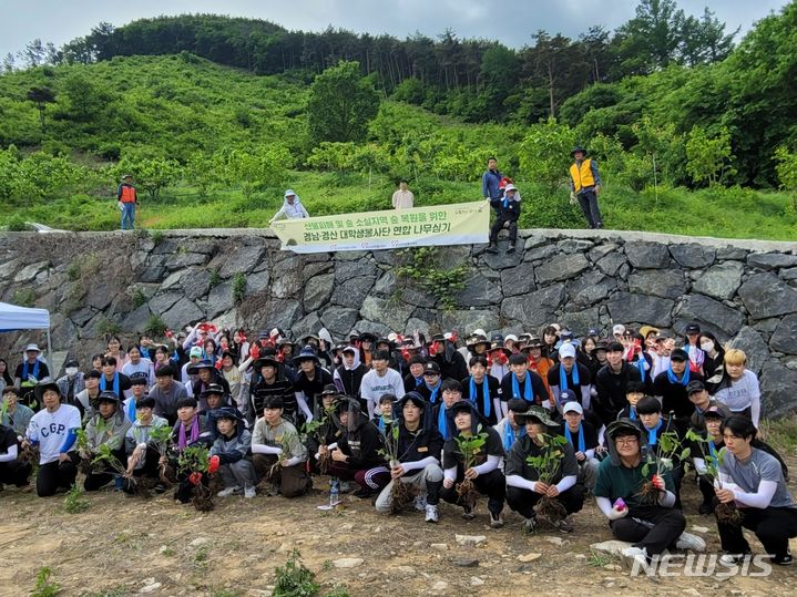 [함양=뉴시스] 11일 경남 함양군 휴천면 일대 산에서 경남 대학생봉사단과 경북 경산 대학생봉사단 160여 명이 참나무 3000주 식목 활동을 마친 후 기념촬영하고 있다.(사진=경상남도자원봉사센터 제공) 2024.05.11. photo@newsis.com